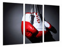 Tríptico guantes de boxeo rojos, colgando sobre fondo negro