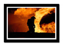 Cuadro enmarcado negro Oficio, Bombero apagando fuego en atardecer